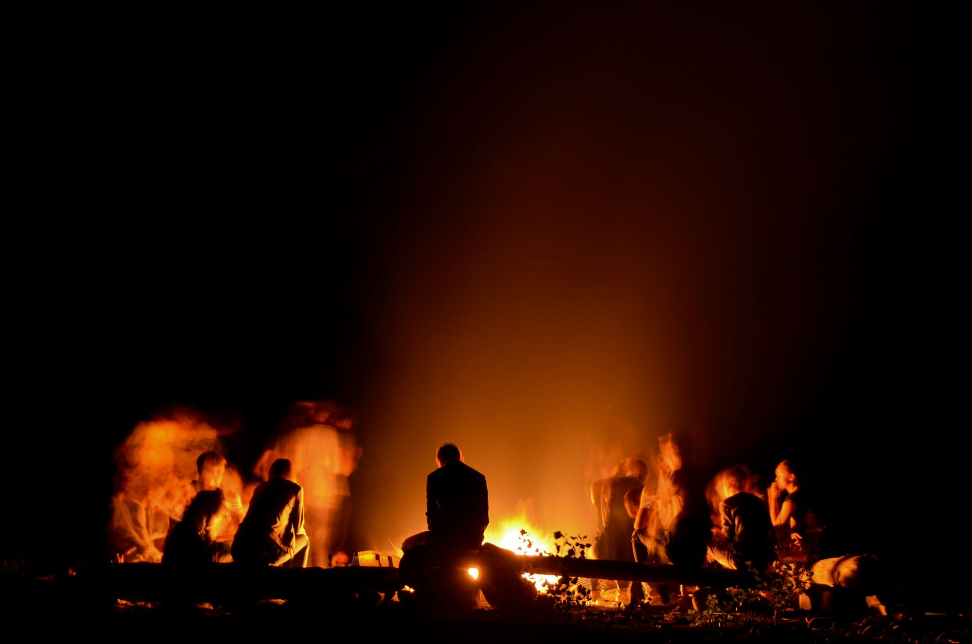 Group of people around a campfire at night
